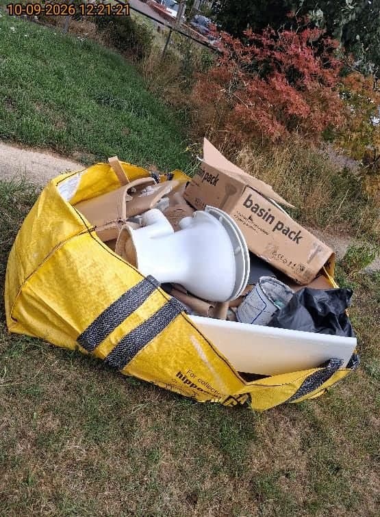 Bulk bag filled with bathroom strip-out waste including an old toilet, basin, paint tin and packaging ready for collection