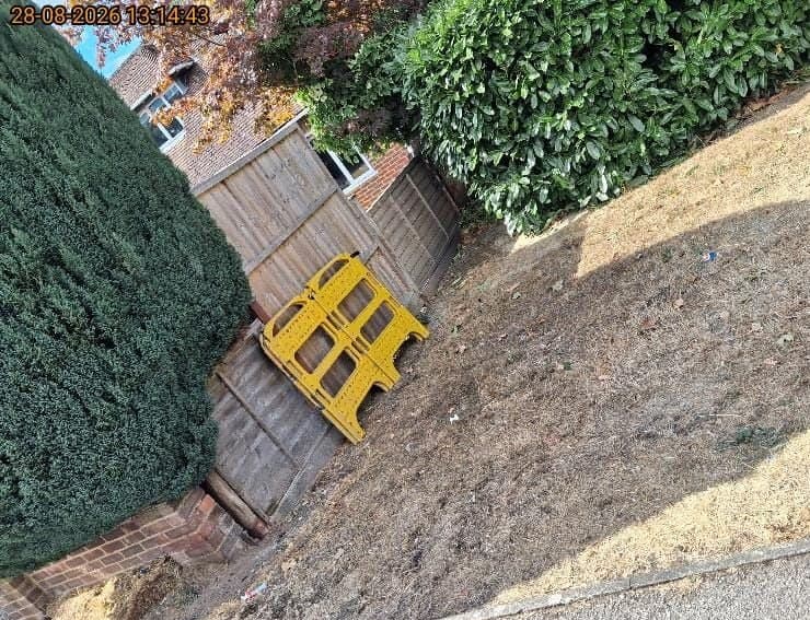 Stack of yellow folding safety barriers collected from a garden