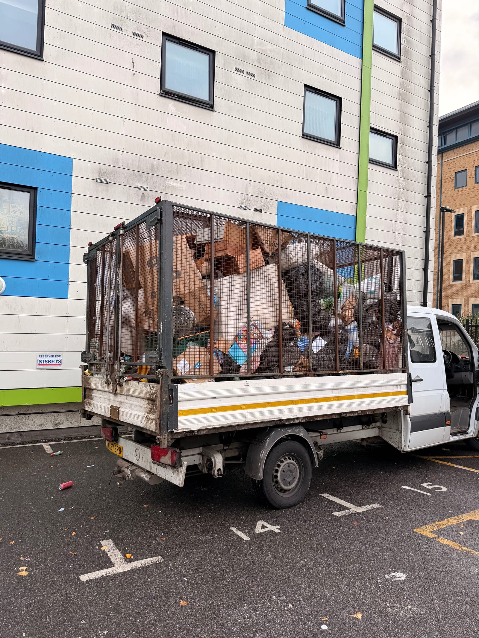 Caged tipper truck fully loaded with cleared waste and cardboard